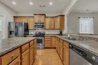 Featuring stainless appliances, recessed lighting, and a spacious bar that opens seamlessly the living room.