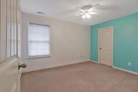 The second of the upstairs bedrooms also features a ceiling fan and spacious closet!