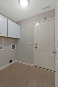 Spacious separate laundry room with storage cabinets is conveniently accessed from the garage!