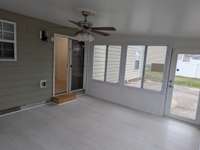 Sunroom off the kitchen with a concrete patio just outside is perfect for barbecuing!
