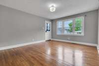 Neutral tones, gleaming hardwoods, and lots of windows make this living area feel bright and spacious.