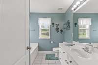 Relax in a spacious primary bath featuring a garden tub, walk-in shower, and natural light!