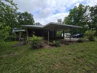 view from side yard showing carports and covered private backporch