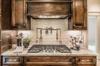 Five burner gas cooktop with magnetic knife block and tools for ease of use.