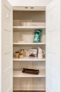 Kitchen pantry with wood shelving.