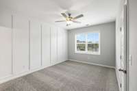 14x11 Primary Bedroom Featuring Judge's Panelling Accent Wall. Photo is of a previously built home with the same floor plan, selections may vary.