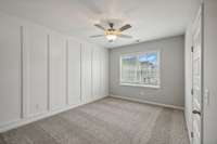 14x11 Primary Bedroom Featuring Judge's Panelling Accent Wall. Photo is of a previously built home with the same floor plan - selections may vary.
