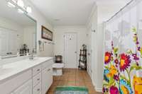 Large primary bathroom with double vanities, shower with a fiberglass seat.  Updated toilet with dual flush control.  A huge linen closet approx. 6'x2' deep.  Additional floored attic storage access.