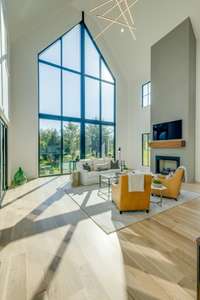 The combination of hardwood flooring, neutral paint, and large windows allows natural light to flow freely throughout the home