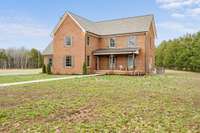 Covered front porch overlooks secluded treelined acreage