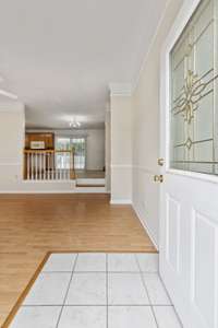 As you enter the front door welcomes you with an artistic glass inlay into a bright living room, where a lofted kitchen and dining area overlook the space, creating an inviting atmosphere.