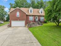 Inviting property featuring full-growth trees in both the front and back yards. Plenty of grass surrounds the home, creating a welcoming outdoor setting. The spacious driveway provides ample parking for multiple vehicles.