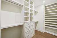Huge walk-in closet adjacent to spa-like primary suite. Custom built-in shelving and drawers from floor to ceiling.