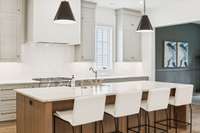 Gorgeous kitchen with oversized island, tons of counter space, designer lighting and counters, custom cabinetry and built-in appliances