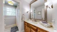 The upstairs hall bathroom from the hall doorway.  The mirror is so large and beautiful.