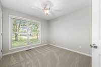 Bedroom # 3 with neutral paint, ceiling fan, new carpet and double window overlooking the front yard.
