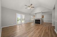 Vaulted living room with double sided gas fireplace and french doors for lots of natural light.