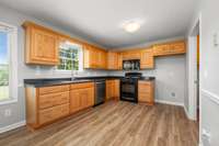 The kitchen is well appointed with oak cabinets and a window overlooking the backyard.