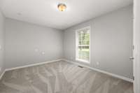 Bedroom # 2 with new carpet, neutral paint and a window overlooking the front yard.