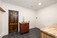 The lower level laundry room has a sink and counter for folding.