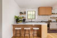 The kitchen peninsula has Brazilian Thassos marble countertops and a rounded edge.
