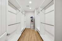 Custom large walk in primary closet with clothing racks, shoe storage, and.....