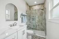 Secondary ensuite bath. Shower has linear drain and tile all the way to the ceiling.