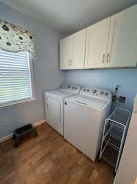 Full utility room with built-in upper cabinets.