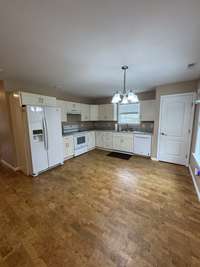Full kitchen complete with smooth top stove and cork flooring.