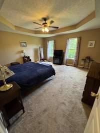 Huge primary bedroom with tray ceiling, ceiling fan and lots of room for all your bedroom furniture .