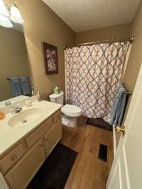 Full hall bath with oak hardwood flooring.