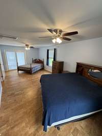 Super large bedroom that can easily accomodate two beds if needed. This is a king and a queen currently in the room. There is also doors leading out to the deck.