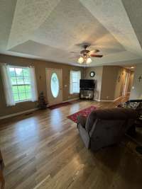 Living room with durable oak hardwood flooring and vaulted ceiling