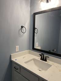 Chic powder room with contemporary fixtures, stylish vanity, and designer lighting. A polished space that blends function and flair—perfect for guests and daily convenience with a touch of elegance.