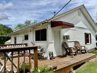 The side of the house shows the large deck that was added on the back of the home