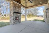 Gorgeous covered back porch with fireplace and wood ceiling!