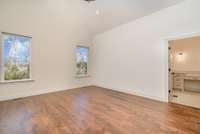 Large primary bedroom also features cathedral ceiling.