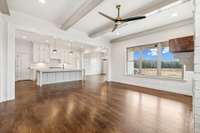 Large window in living room, wood beam ceiling and fireplace