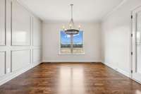 Dining room features trim accent wall, window to backyard, and door to covered porch