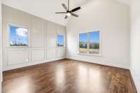 Primary bedroom features cathedral ceiling and accent trim wall