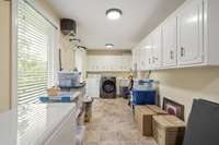 Large Laundry Room 23x7 with sink and ample cabinet storage overlooking the front yard.
