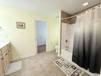 Jack & Jill Bath with tub/shower combo with tile flooring