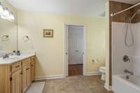 Large Jack & Jill bathroom features tile flooring with tub/shower custom vanity;