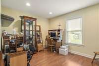 Flex/Office behind the See Thru Fireplace with hardwood flooring overlooking fenced backyard area