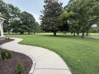 Winding concrete sidewalk to the covered front porch!