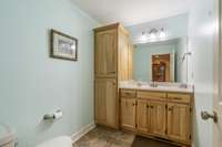 Half Bath with custom cabinets and tower with marble vanity; Flows from Kitchen/Dining Room