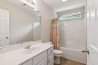 Full upstairs hall bathroom with long vanity.