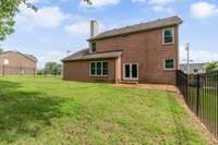 Exterior rear view of home. All brick, new patio door and new windows.
