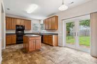 Kitchen with newer ceramic tile floor, island and brand new patio doors.