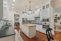 Stainless Bosch appliances, a gas cooktop, custom range hood, and an island with butcher block tops and storage on both sides!  Ample cabinetry and storage in this kitchen.